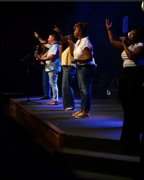 The worship team together under stage lights